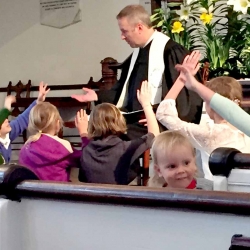 Kids raise their hand during a participatory children's time at the First Congregational Church of Stockbridge