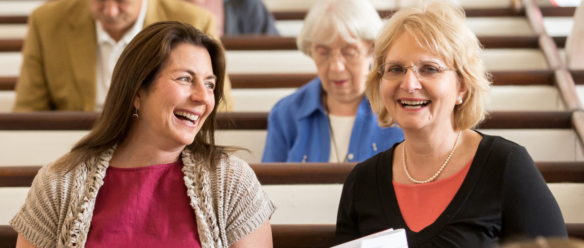 Two women smile in the sanctuary of the Stockbridge Congregational Church