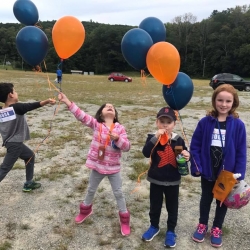 A group of kids holding a balloon