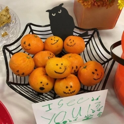 A baskety of clementines decorated for Halloween