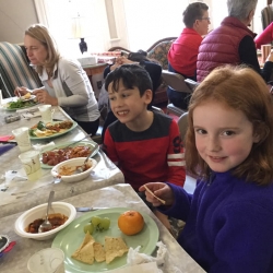 Two children eat at a potluck