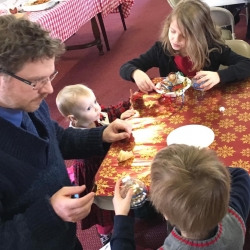 A father and his children make Christmas ornaments