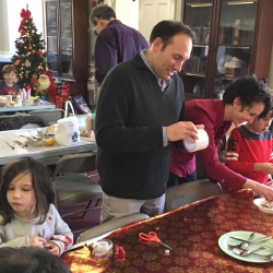 Two parents and their children make Christmas ornaments