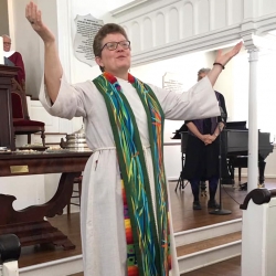 Rev. Patty Fox lifts her hands before the congregation in blessing