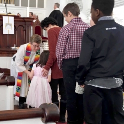 Rev. Patty Fox gives communion to a young girl