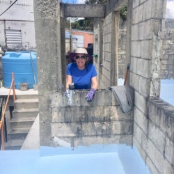 A woman paints a floor