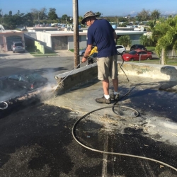 A man power washes a roof