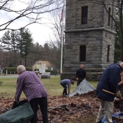 Workers attack a large pile of leaves