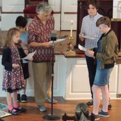 Children and adults perform in a live Sunday School radio play