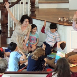 Children and adults sit on the floor and listen to the children's sermon