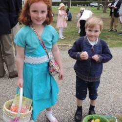 A brother and sister hold their Easter eggs up proudly