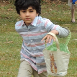 A boy runs across the lawn looking for Easter eggs