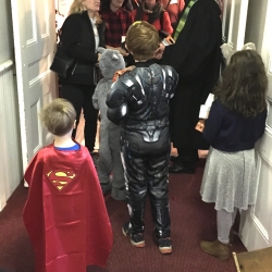 Children in Halloween costumes await adults coming out of worship