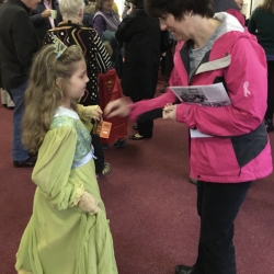 A girl dressed as a princess receives a donation
