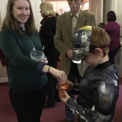 A boy in a star wars costume receives a donation