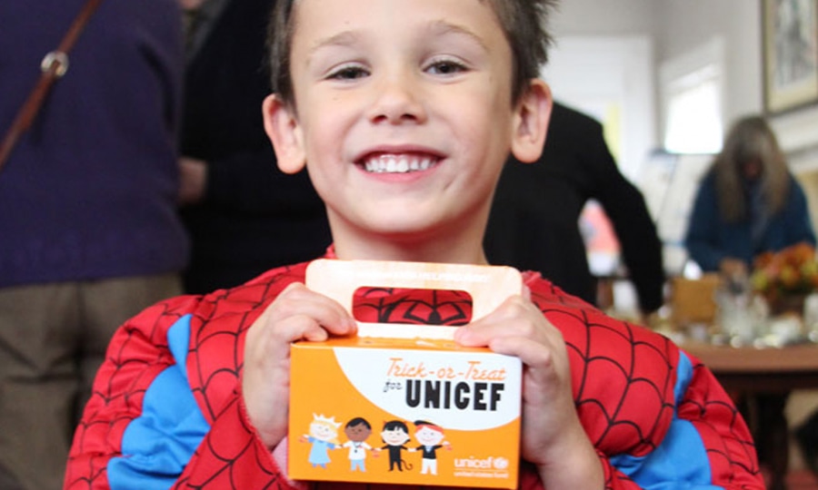 A boy dressed as Spiderman trick-or-treats for UNICEF