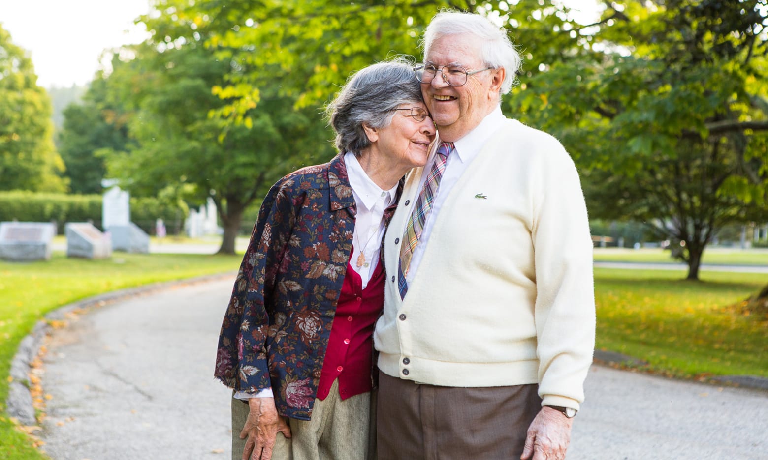 An elderly wife and husband laugh and hug each other