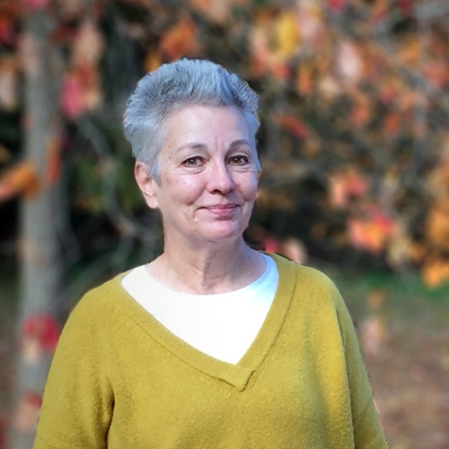 A woman with fall leaves in the background