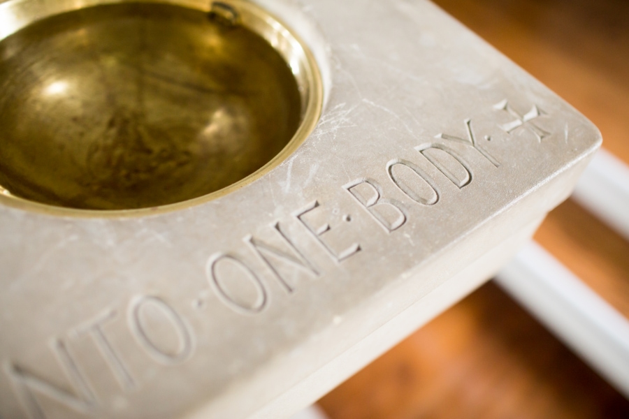 Baptismal font inscribed with the words "One Body"