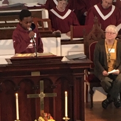 A teenage boy reads scripture in the pulpit