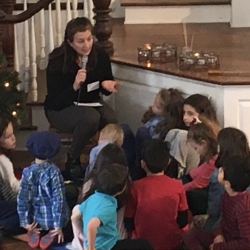 A woman offers the Children's Sermon on refugees to a group of children.