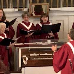 A man leads the church choir in an anthem