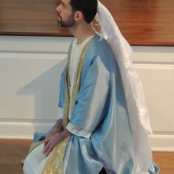 A man dressed as the Archangel Gabriel kneels before the voice of God