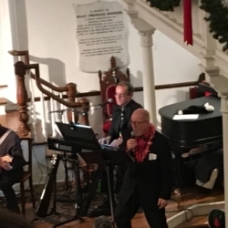 John Demler sings while accompanied by a jazz trio