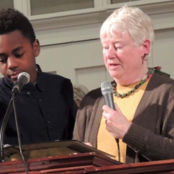 A middle-aged woman and teenage boy read from the Bible
